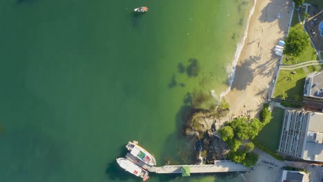 Luftaufnahme-Von-Oben-über-Die-Küste-Eines-Brasilianischen-Paradiesstrandes-Mit-Weißem-Sand,-Smaragdgrünem,-Klarem-Wasser,-Booten-Und-Felsen