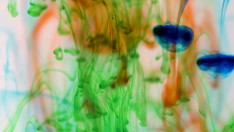 Slow-motion-abstract-footage-of-colored-ink-droplets-combining-in-liquid