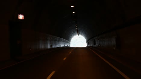 The-light-at-the-end-of-the-tunnel,-travelling-by-car-through-a-man-made-high-way-tunnel