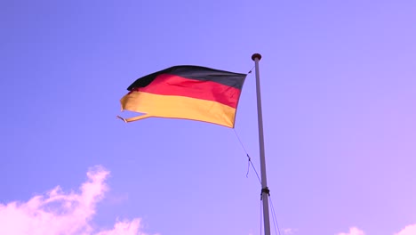 Wind-blowing-the-German-flag-with-moving-clouds-and-blue-sky-in-the-background