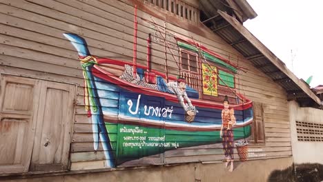 Graffiti-Local-En-La-Pared-De-La-Casa-De-Madera-En-Un-Pueblo-De-Pescadores,-Chonburi,-Tailandia