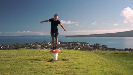 SLOWMO---Young-caucasian-tourist-standing-on-metal-mushroom-sculpture-vent-on-Mount-Victoria,-Auckland,-New-Zealand
