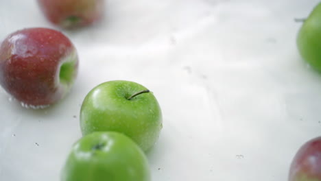SLOMO-of-Apples-in-Water-on-White-Backdrop