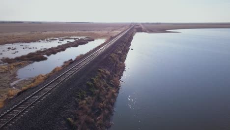 Empty-train-tracks-border-a-pond-on-the-flat-prairie
