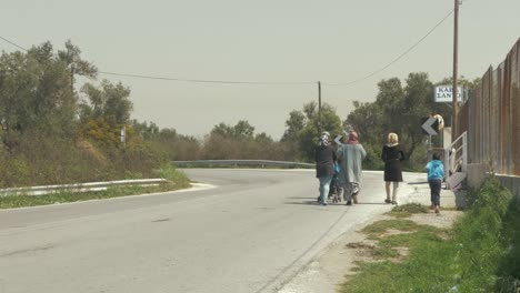 Refugees-walk-along-road-in-Greece-hot-Summers-day