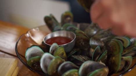 SLOWMO---People-eating-plate-of-freshly-caught-New-Zealand-greenshell-mussels-on-boat