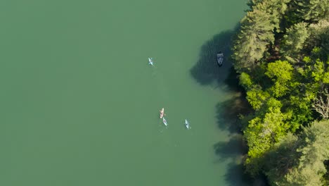 A-Birdseye-view-of-people-kayaking-and-fishing-on-a-lake-near-a-forest-in-Wisconsin,-USA