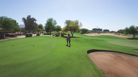 Golfistas-Aéreos-Caminan-Hasta-El-Tee-Box-Llevando-Conductores,-Scottsdale,-Concepto-De-Arizona:-Caridad,-Pliegues-De-Honor,-Deportes