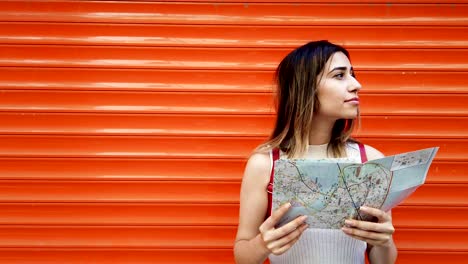 Slow-Motion:Beautiful-young-girl-looks-at-map-of-Istanbul-with-orange,red-background
