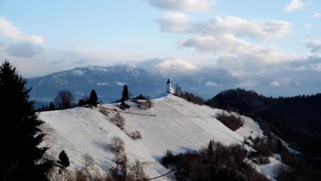 View-of-Jamnik-Church-in-a-winter-landscape-with-colourful-sunrise-in-Kranj,-Slovenia