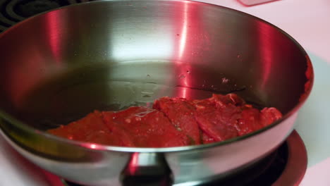 Frying-meat-in-a-pan-under-creepy-red-light