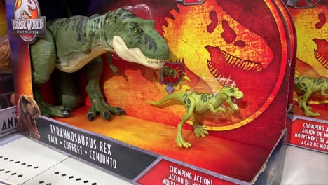 Nahaufnahme-Einer-Kinderhand,-Die-Die-Kiefer-Einer-Verpackten-T-Rex-Actionfigur-Aus-Der-Jurassic-World-Legacy-Kollektion-Von-Mattel-öffnet-Und-Schließt