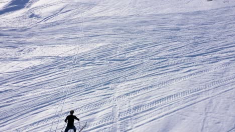 Aerial-view-of-man-skiing-up-snowy-hill