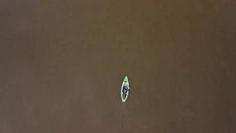 Birds-eye-view-of-a-man-kayaking-down-a-river