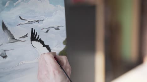 Close-Up-Footage-of-Painters-Hands-Adding-Black-Watercolour-With-Brush-on-Flying-Stork-Birds-Painting-in-Painting-Academy