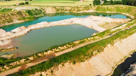 Aerial-shot-from-a-drone-of-quarry-and-heavy-machinery-in-pomeranian-district-in-Poland,-showing-lakes-created-by-man