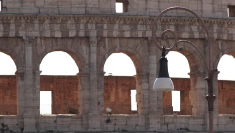 Static-shot-of-street-metal-lantern-lamp-against-the-Colosseum-in-Rome,-Italy