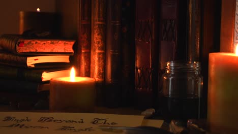 Close-up-background-of-an-ancient-library,-next-to-a-frieplace,-with-old-books,-a-feather,-old-paper,-ink,-stones,-and-candles-with-flickering-flames,-with-some-dust-flying-around