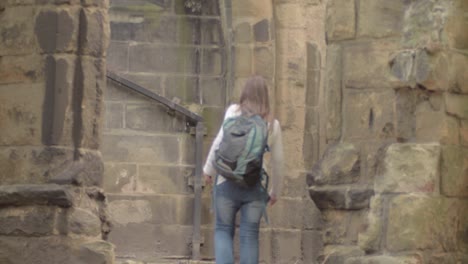 Woman-walking-through-ruins-of-old-church-in-England