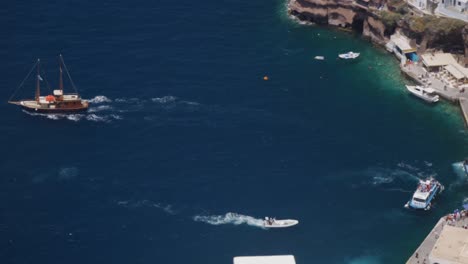 Hoher-Winkel,-Nähere-Weitwinkelaufnahme-Des-Bootes,-Das-Den-Hafen-Von-Thira-Auf-Santorini,-Griechenland,-Verlässt