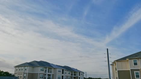 Time-lapse-of-clouds-moving-over-apartment-complex,-clearing-weather-front-revealing-blue-skies-Texas