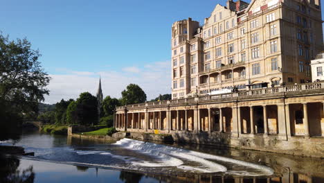 Static-Shot-of-Pulteney-Weir-and-the-Empire-Hotel-in-Bath,-Somerset-on-Beautiful-Summer’s-Morning-with-Blue-Sky-and-Golden-Light