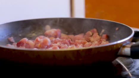 Bacon-is-cooked-and-stirred-in-a-frying-pan
