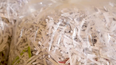Close-up-pan-over-a-bag-of-shredded-paper-waiting-to-be-recycled