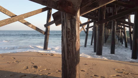 Panning-shot-under-pier-in-Seal-Beach,-California