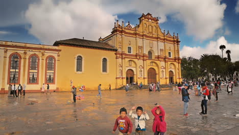 MAIN-CATHEDRAL-AND-KIDS-PLAYING-IN-SAN-CRISTOBAL-DE-LAS-CASAS,-CHIAPAS-MEXICO-SHOT-PEOPLE-PASSING-BY