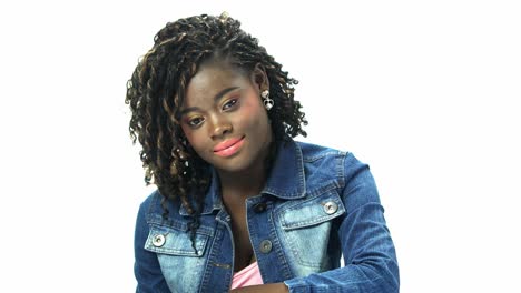 Junge-Afroamerikanische-Teenagerin-Der-20er-Jahre-Schwarzes-Alfro-Haar-Mit-Kosmetischem-Make-up-Im-Gesicht-In-T-Shirt-Jeansjacke-Drückt-Emotionen-Auf-Weißem-Hintergrund-Für-Virales-Clip-Casting-Oder-Werbung-Aus
