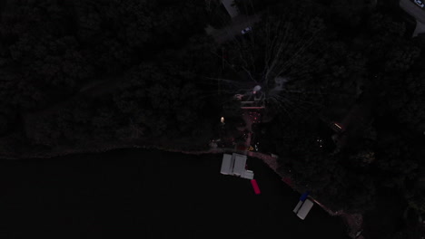 Drone-flying-over-large-mortar-fireworks-being-shot-over-a-lake-on-4th-of-July