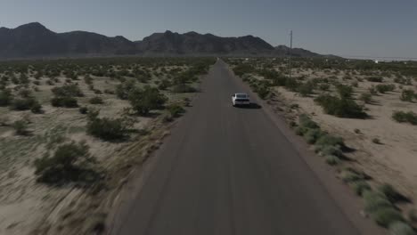 Drone-shot-of-a-mustang-driving-on-dirt-road