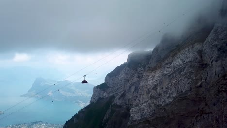 Aerial-view-of-a-cable-car-driving-up-and-disappears-in-the-fog