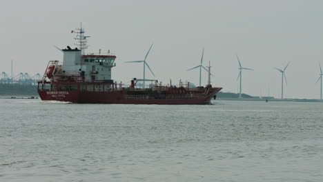 Tanker-entering-to-port-in-Netherlands-where-working-wind-turbines