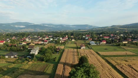 Zoom-effect-from-aerial-footage-of-a-village-and-mountains-in-the-background