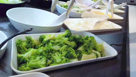 Fresh-green-broccoli-in-salad-bar-station-were-picked-into-the-dish