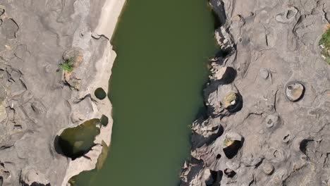 Aerial-drone-footage-of-a-river-with-potholes---At-Nighoj-near-Pune-and-is-famous-for-the-naturally-created-potholes-on-the-riverbed-of-the-Kukadi-River