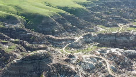 High-aerial-pass-over-badlands-and-terrain-in-Alberta,-Canada