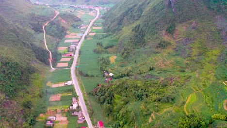 A-road-cuts-through-a-lush-vibrant-valley-on-the-Dong-Van-Karst-plateau-geopark