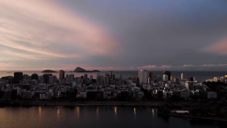 Reveal-of-Ipanema-neighbourhood-with-islands-off-of-the-coast-in-the-distance-seen-from-above-the-city-lake-Lagoa-Rodrigo-de-Freitas-in-Rio-de-Janeiro
