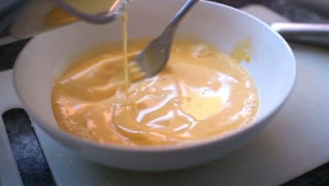 adding-cream-into-egg-yolk-ad-stirring-with-a-fork-in-slow-motion