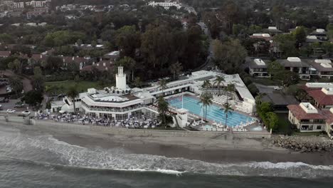 Aerial-drone-forward-footage-shot-over-beach-in-Santa-Barbara,-towards-large-hotel