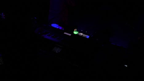 Organ-musician-in-the-dark-with-the-lights-flashing-live-on-concert-backstage-behind-the-band