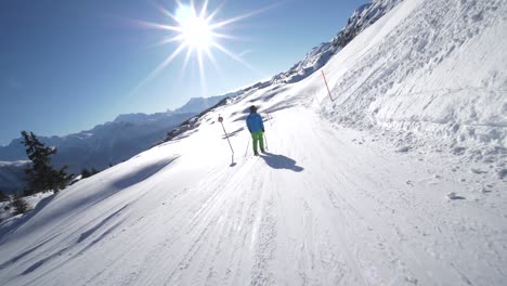 STABILIZED-TRACKING-SLOW-MOTION:-young-skier-skiing-on-a-beautiful-winter-day-on-perfect-slope-with-amazing-mountain-scenery-in-the-swiss-Alps-during-sunny-day