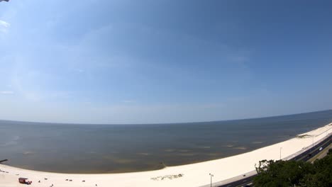 time-lapse-daytime-view-of-beach---ocean,-few-clouds,-wind-blowing-water-away-from-beach---14th-story-view-of-nearly-wave-less-beach-in-gulf