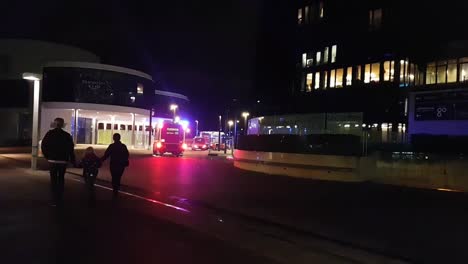 A-family-walking-past-firetrucks-during-an-emergency-with-their-lights-on