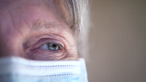 Close-up-of-an-old-woman-face-wearing-a-medical-mask-in-the-hospital-to-prevent-contagious-disease-and-sickness
