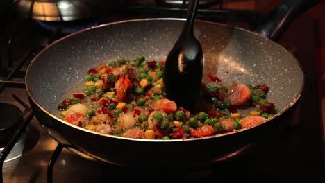 Mixing-frozen-vegetables-on-the-hot-pan-with-plastic-spoon