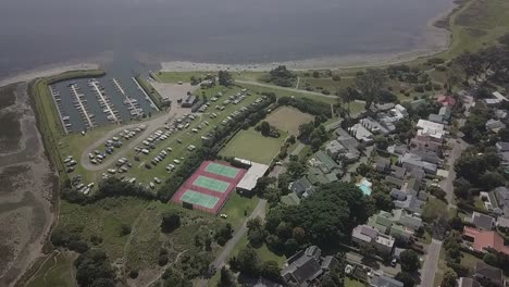Leisure-Island-Marina,-empty-tennis-courts-in-Knysna,-S-Africa-aerial